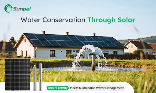 House with solar panels on the roof near a water pump spraying water in a grassy field.
