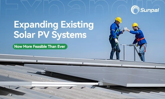 Two workers in safety gear collaborating on a rooftop solar panel installation.
