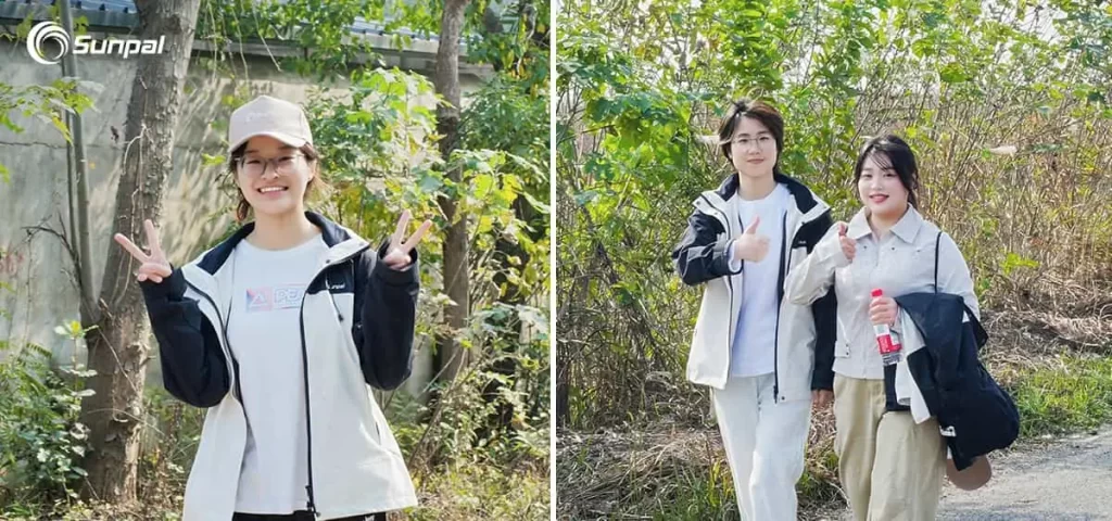 Two Sunpal Solar team members outdoors during autumn, one making a peace sign and the other giving a thumbs-up, symbolizing empowerment and collaboration.