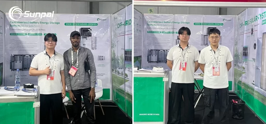 Sunpal staff pose with a visitor at their exhibition booth displaying BESS and PV system posters; two team members stand side‑by‑side.
