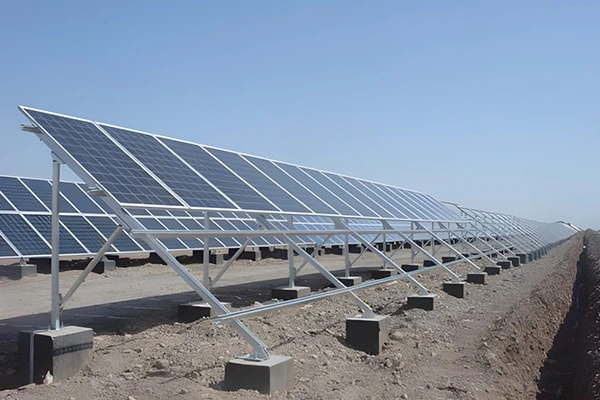 Angled distant view of 3MW ground-mounted solar project in South Africa showing overall panel layout and concrete foundation distribution