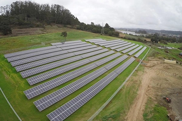 Front distant view of 2MW ground-mounted solar project in Italy showing PV panel layout and mounting structures