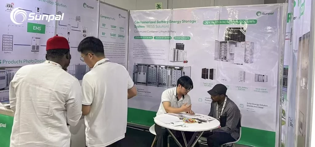 Sunpal representatives discuss product brochures and technical details with visitors at a booth displaying BESS and PV system posters.
